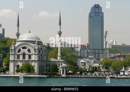 Türkei kontrastreiche Architektur entlang des Bosporus, Istanbul. Ortakoy-Moschee im Vordergrund, auf dem Bosporus Stockfoto