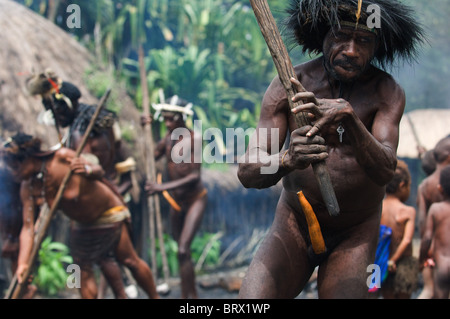 -Geh weg! Die Papua verbannt aus dem Dorf einen Stock geschwungen. Indonesien. Papua-Neu-Guinea. Dorf von Menschen Dani Dugum. Stockfoto