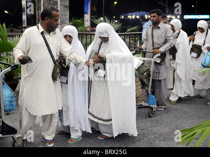 Pakistanische Muslime stehen in Warteschlange, wie sie für die jährliche Pilgerfahrt in Saudi Arabien, Karachi Flughafen fahren Stockfoto