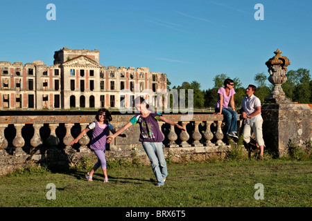 KINDER SPIELEN MIT DER FAMILIE VOR DER RUINE DES CHATEAU DE LA FERTE-VIDAME, EURE-ET-LOIR, FRANKREICH Stockfoto