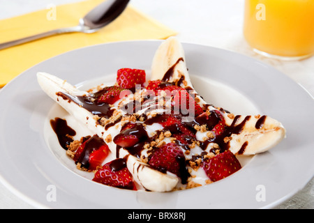 eine gesunde Platte von Bananensplit mit Joghurt, Erdbeeren und niedrigen Fett hot Fudge topping Stockfoto