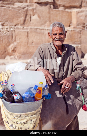 Älteren ägyptischen Mann verkaufen Erfrischungen an der Basis der großen Pyramide, Gizeh, Ägypten. Stockfoto