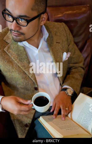 Hohe Betrachtungswinkel von reifer Mann Kaffee trinken und Lesen Buch Stockfoto