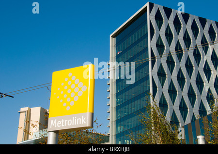 Metrolink-Zeichen und der Salford University "Orange" Gebäude aus der MediaCityUK Straßenbahn zu stoppen.  Salford Quays, Manchester, UK. Stockfoto