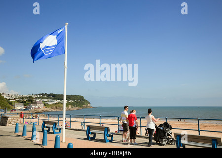 Blaue Flagge an der Strandpromenade mit Blick auf den Strand in walisischen Küstenort Benllech, Isle of Anglesey, North Wales, UK, Großbritannien fliegen Stockfoto