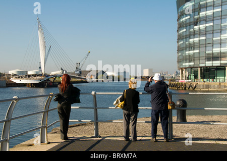 Touristen auf der Suche an die neue Schaukel Fußgängerbrücke im Bau an der MediaCityUK Komplex, Salford Quays, Manchester, UK Stockfoto