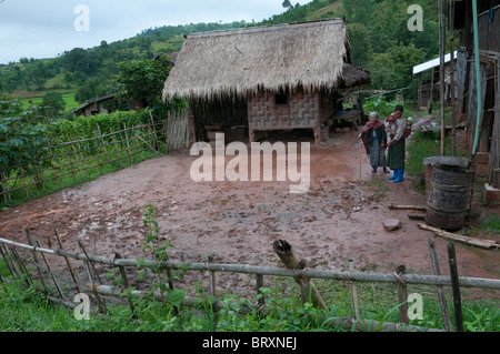 Landwirte in den schlammigen Courtuyard ihre Farm in einem Shan Hills Village stehen. Shan-Staat. Myanmar Stockfoto