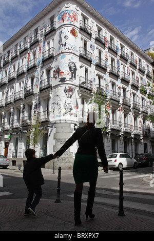 MUTTER UND KIND VOR EINEM GEMALTEN GEBÄUDE AUF DER CALLE CAMPOAMOR, CHUECA VIERTEL, MADRID, SPANIEN Stockfoto