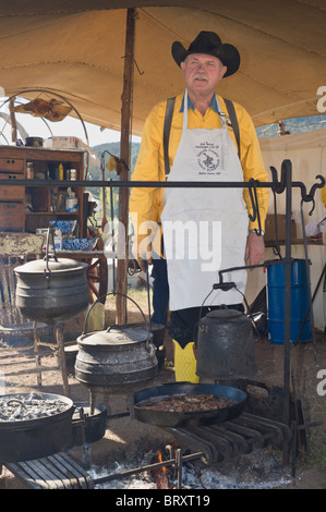 Chuck Wagon Koch neigt am Lagerfeuer, im Lincoln County Cowboy Symposium und Chuck Wagon Kochwettbewerb, Ruidoso Downs, New Mexico. Stockfoto