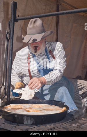 Zigarre rauchende Cowboy Koch, an der Lincoln County Cowboy Symposium und Chuck Wagon Kochwettbewerb, Ruidoso Downs, New Mexico. Stockfoto