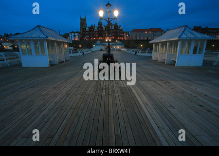 Cromer Pier an der Küste von Norfolk am frühen Abend wit die Stadt hinter. Stockfoto