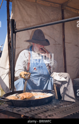 Zigarre rauchende Cowboy Koch, an der Lincoln County Cowboy Symposium und Chuck Wagon Kochwettbewerb, Ruidoso Downs, New Mexico. Stockfoto