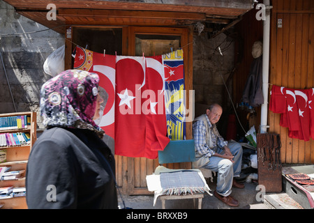 Frau mit Kopftuch geht vorbei an einem Stall zu verkaufen Türkische Flaggen in den großen Basar, Istanbul, Türkei, Europa Stockfoto