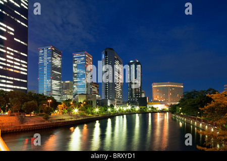 Bürogebäude und Fluss in der Nacht, der Präfektur Osaka, Honshu, Japan Stockfoto