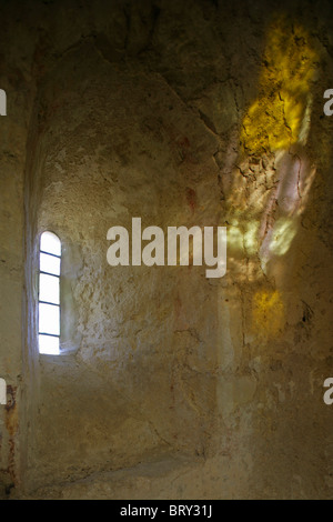 Sonnenlicht auf Steinmauer durch Glasfenster in der alten Kirche. Stockfoto