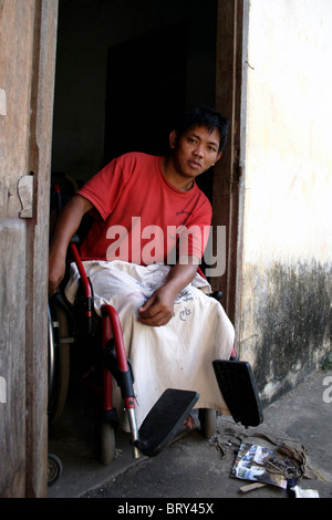 Ein 25 Jahres altes männliche UXO Opfer sitzt in der Tür ein Krankenzimmer im National Rehabilitation Center in Vientiane Laos. Stockfoto