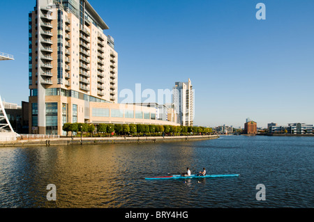 Zwei Personen Wriggen (Rudern) auf den Manchester Ship Canal in der Nähe von Lowry Outlet Mall, Salford Quays, Manchester, UK Stockfoto