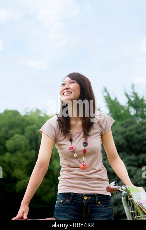 Junge Frau lächelt und wegsehen Stockfoto