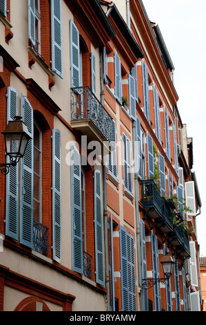 Schöne rote Backsteinhäuser mit weißen Fensterläden auf der Croix-Baragnon Straße, Toulouse, France Stockfoto