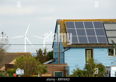 Windkraftanlagen hinter einem Haus mit Solarzellen recycelt Haus Camber Roggen East Sussex Stockfoto