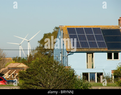 Windkraftanlagen hinter einem Haus mit Solarzellen recycelt Haus Camber Roggen East Sussex Stockfoto