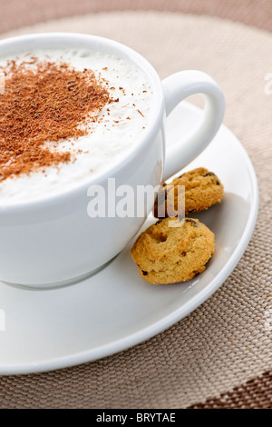 Cappuccino oder Latte, die in Tasse mit Milchschaum und Cookies Kaffee Stockfoto