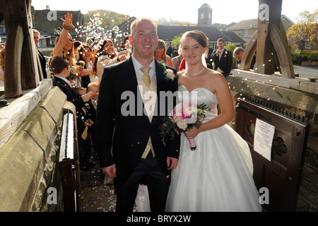 Eine junge Braut und Bräutigam haben Konfetti geworfen über sie am Tag ihrer Hochzeit Stockfoto