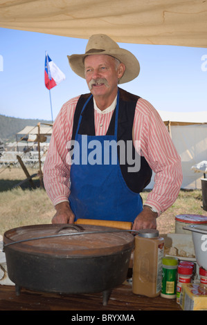 Ein Planwagen Koch bereitet Mittagessen im Lincoln County Cowboy Symposium und Chuck Wagon Kochwettbewerb, Ruidoso Downs, New Mexico. Stockfoto