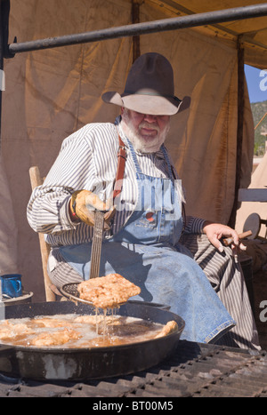 Zigarre rauchende Cowboy Koch, an der Lincoln County Cowboy Symposium und Chuck Wagon Kochwettbewerb, Ruidoso Downs, New Mexico. Stockfoto