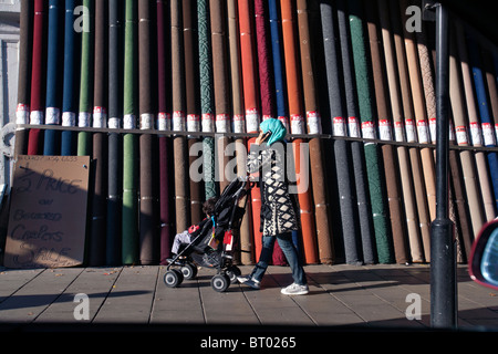 asiatische Frau vorbeigehen Teppiche in Hackney, london Stockfoto