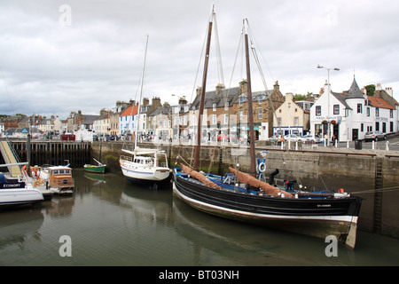 Anstruther Hafen mit verschiedenen Booten und Souvenirläden im Hintergrund. Stockfoto