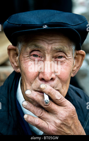 Porträt eines alten chinesischen Mannes mit einem klassischen "Mao" Hut und Hemd. Stockfoto