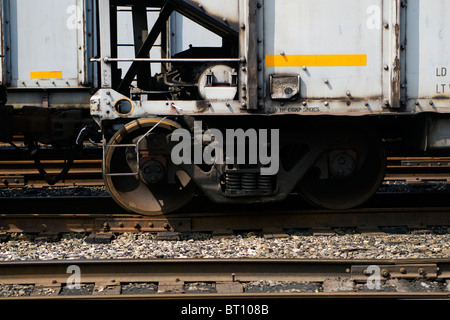 Eine Nahaufnahme eines Satzes von Eisenbahnrädern auf einem Kohle-Auto auf Eisenbahnschienen. Diese sind typisch für moderne Schienenfahrzeuge in Eisenbahn. Stockfoto
