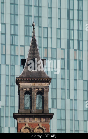 Turm der ehemaligen Knott Mühle Kapelle, Deansgate, Manchester, vor dem Hintergrund der Beetham Tower, Hilton Tower. Stockfoto