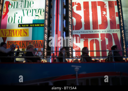 Plakate für Broadway-Musicals hinter einem Tour-Bus sind am Times Square in New York gesehen. Stockfoto