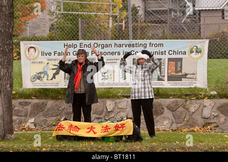 Mitglieder der Falun Gong Übung durch eine Hauptverkehrsstraße Ottawa vor ein Protest-Zeichen Stockfoto