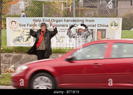 Mitglieder der Falun Gong Übung durch eine Hauptverkehrsstraße Ottawa vor ein Protest-Zeichen Stockfoto
