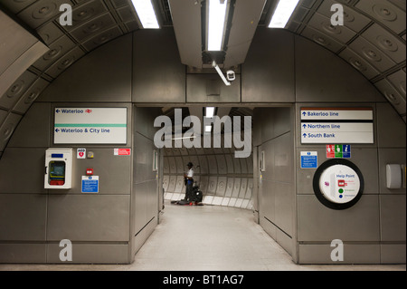 Straßenmusiker mit der Londoner U-Bahn in einem Gehweg zwischen u-Bahn-Linien, an der Waterloo Station, London. Stockfoto