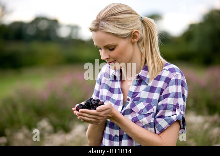Eine Frau hält frisch gepflückt Brombeeren, im freien Stockfoto