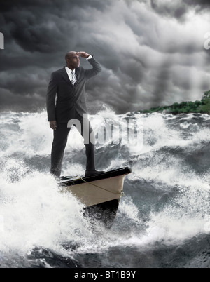 Afrikanische amerikanische Geschäftsmann steht am Ruder des Bootes auf stürmischer See Stockfoto
