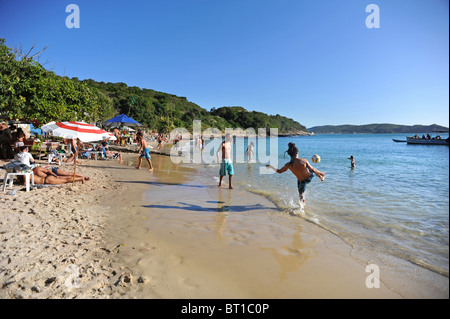 Menschen Sonnen und spielen Fußball auf Joao Fernandes Strand Buzios Stockfoto