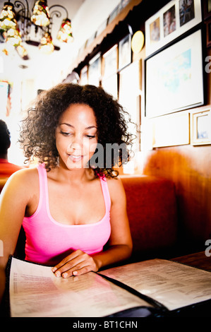 Lächelnd afroamerikanische Frau Lesung Menü im diner Stockfoto