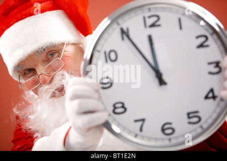 Foto von Santa Holding Uhr zeigt fünf Minuten vor zwölf Stockfoto