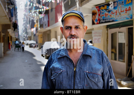 Dieser Mann nennt sich der Mann, der viel arbeitet, lebt er in Boulaq Dakrour, einer der größten informellen Bereichen Kairos. Stockfoto