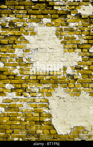 Alte gelbe Wand mit Rissen und grauen Flecken von Gips im Hochformat Stockfoto