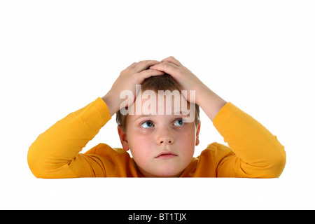 Kleiner hoffnungslos junge hielt seinen Kopf mit beiden Händen ruhen Arme auf leeres Whiteboard isoliert auf weiss Stockfoto