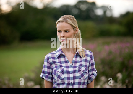 Ein Porträt einer Frau trägt ein lila kariertes Hemd im freien Stockfoto