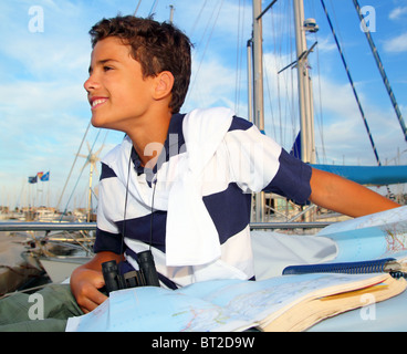 junge Teen Seemann sitzen auf Marina Boot Grafik Karte lächelnd in Sommerferien Stockfoto