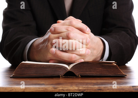 Betende Hände auf eine aufgeschlagene Bibel Stockfoto