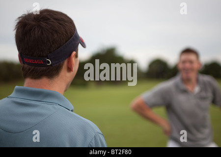 Zwei Golfer necken sich gegenseitig. Stockfoto